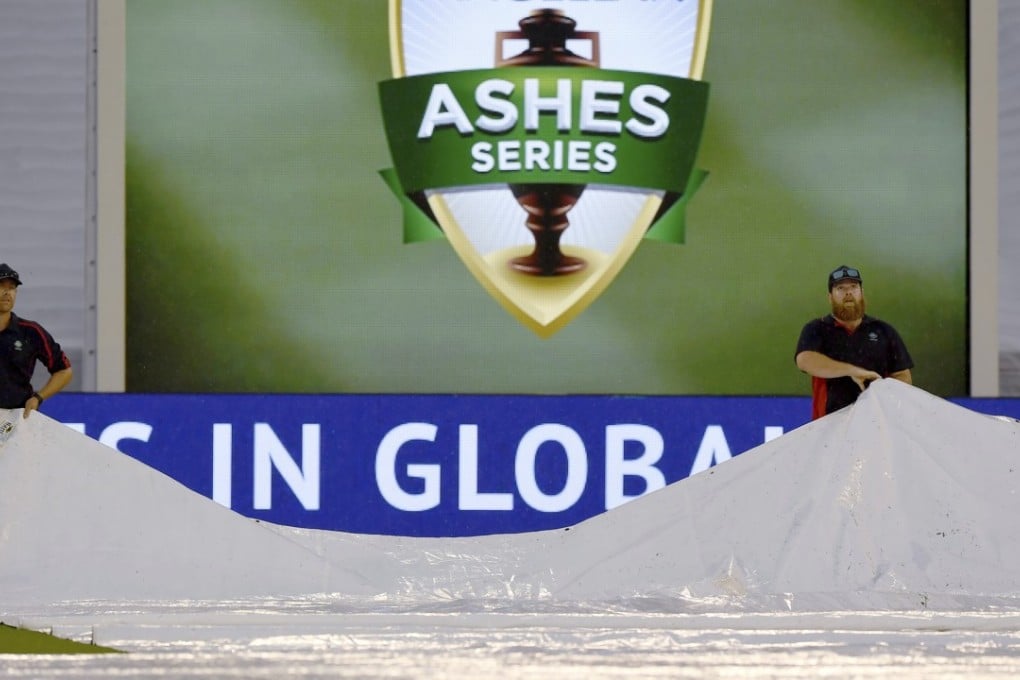 Grounds staff work on the field as rain delays play between England and Australia during the fourth day of their Ashes test in Melbourne. Photo: AP