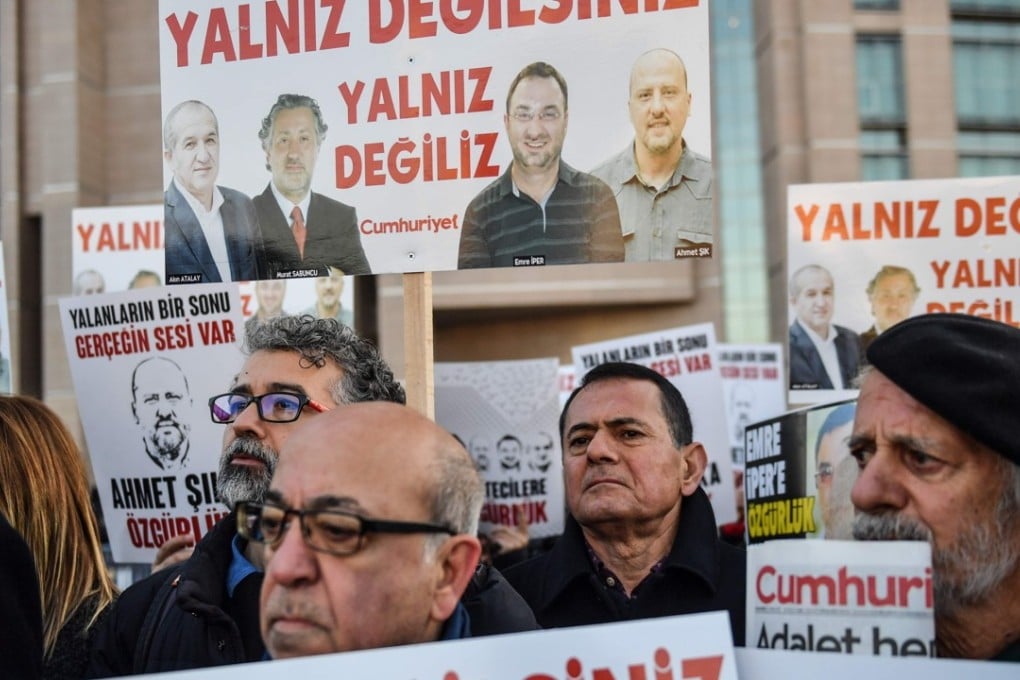 Protesters hold placards with images of jailed journalists and words which translate as “You are not alone” during a demonstration in front of a courthouse in Istanbul on Christmas Day. Turkey is one of several countries that is restricting press freedoms. Photo: AFP