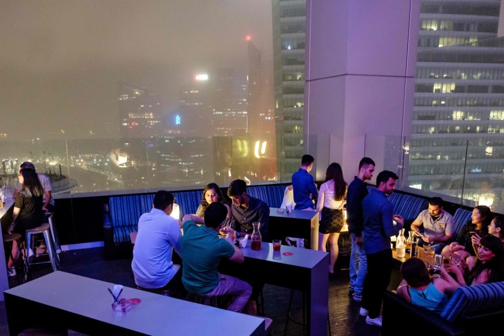 Guests enjoy drinks at the Skyline bar overlooking Singapore’s financial district. Photo: AFP