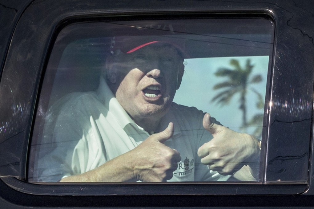 US President Donald Trump gives two thumbs up to cheering supporters from his motorcade heading to his Mar-a-Lago estate after spending the morning at Trump International Golf Club. Photo: AP