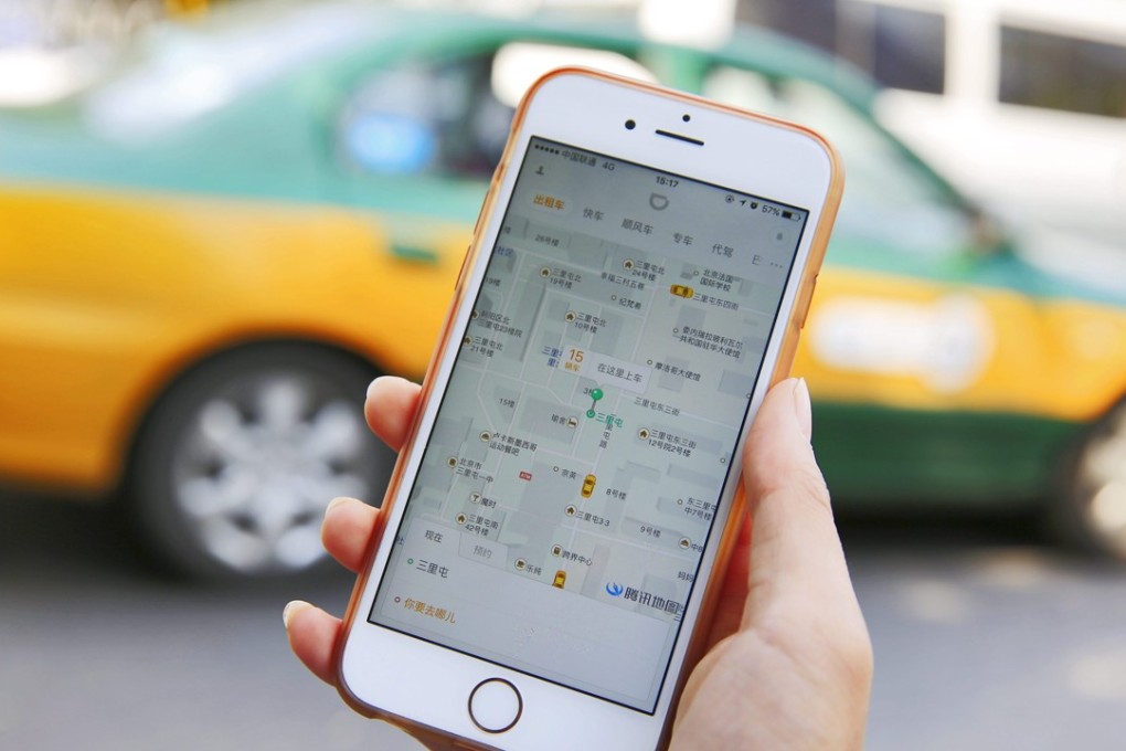 A commuter shows the Didi Chuxing app on her iPhone in Beijing. Didi, the world’s biggest ride- hailing company, is preparing to face online group deals and local services giant Meituan-Dianping as a new competitor in its industry. Photo: EPA
