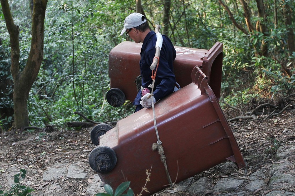 Agriculture, Fisheries and Conservation Department workers remove the last remaining rubbish bins from trails in Lion Rock Country Park, as part of a campaign to encourage hikers to take their garbage home, on December 7. Photo: Roy Issa