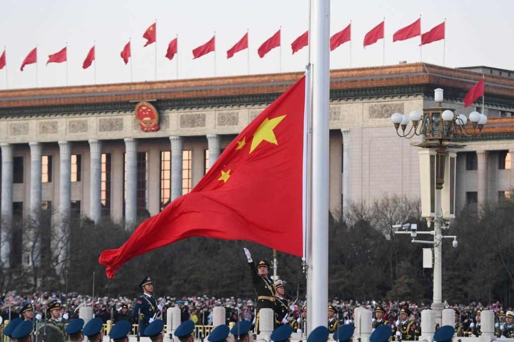 Troops from the army, air force and navy stand guard as the Chinese flag is raised in Tiananmen Square in Beijing on Monday. Photo: Xinhua
