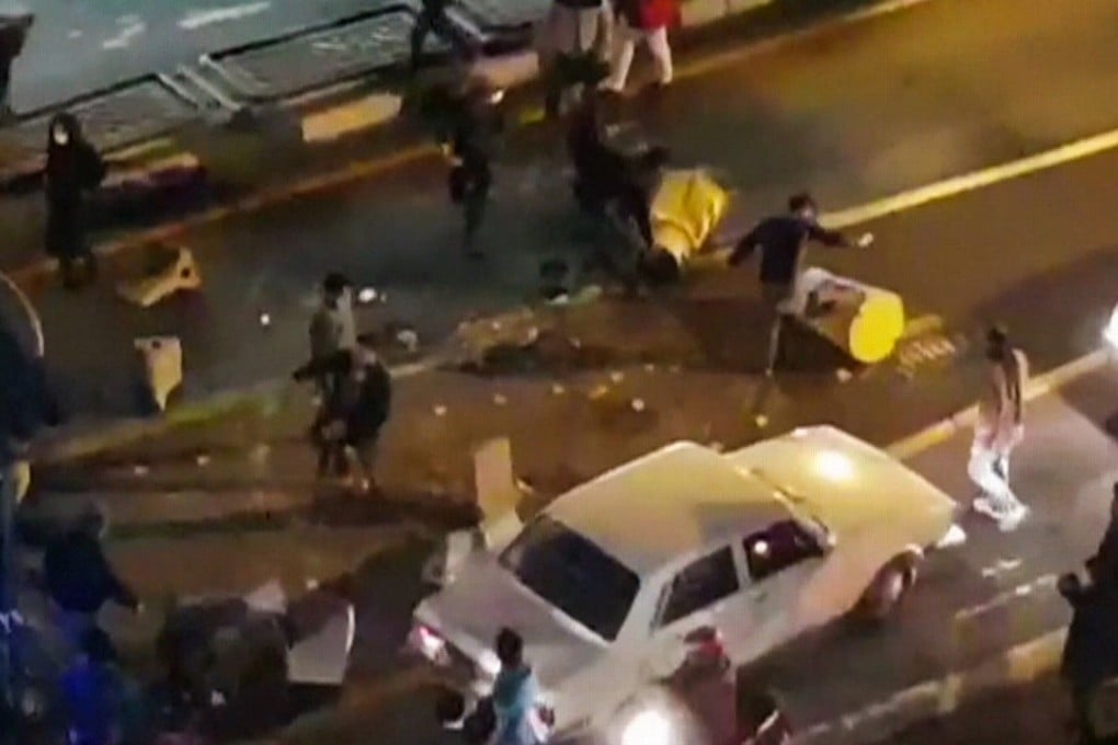 An image grab taken from a video released by Iran’s Mehr News agency reportedly shows a group of men pushing traffic barriers in a street in Tehran on December 30, 2017. Photo: AFP