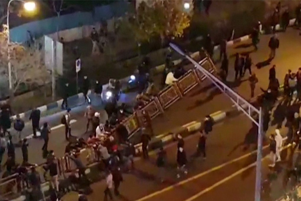 A group of men dismantle a fence in a street in Tehran. Photo: AFP