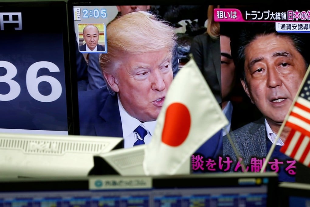 A TV monitor showing US President Donald Trump and Japanese Prime Minister Shinzo Abe next to another monitor showing the Japanese yen's exchange rate against the US dollar. Photo: Reuters