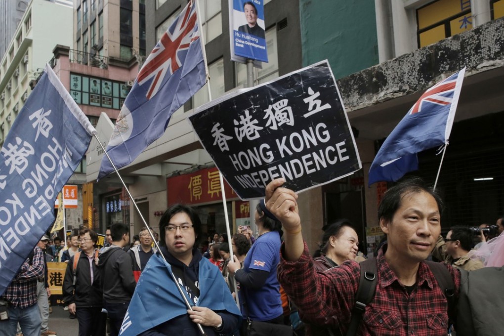 Pro-independence protesters hold placard and wave Hong Kong colonial flags during the New Year rally in Hong Kong, on Monday, January 1, 2018. Photo: AP