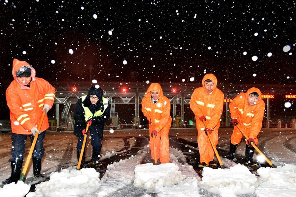 Staff clearing snow at a toll station on an expressway in Yangzhou in Jiangsu province. Photo: Xinhua