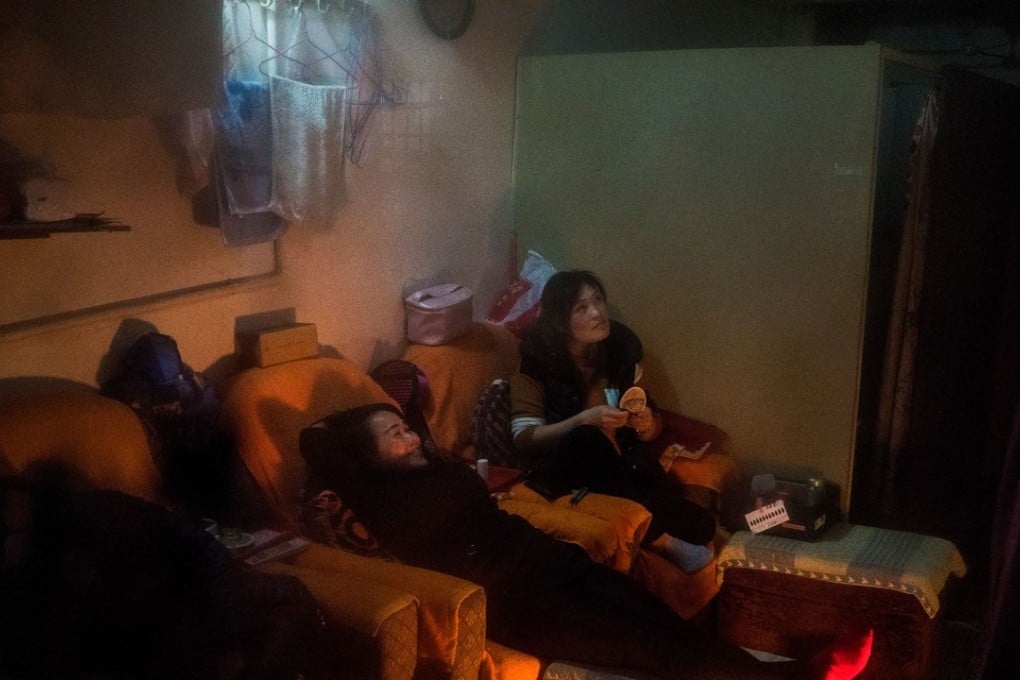 Two women in Shanghai sit round an electric fan heater to keep warm. Photo: Agence France-Presse