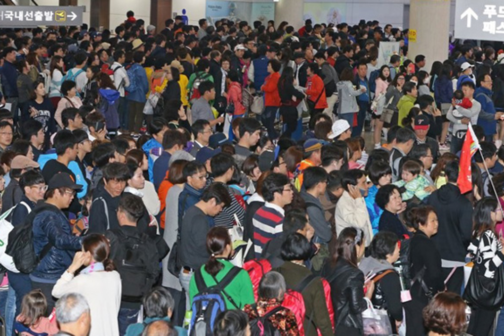Jeju International Airport is crowded with tourists. Jeju residents are protesting the government's project to build a new airport, saying the overwhelming number of tourists are already causing too many problems on the island. Photo: Yonhap