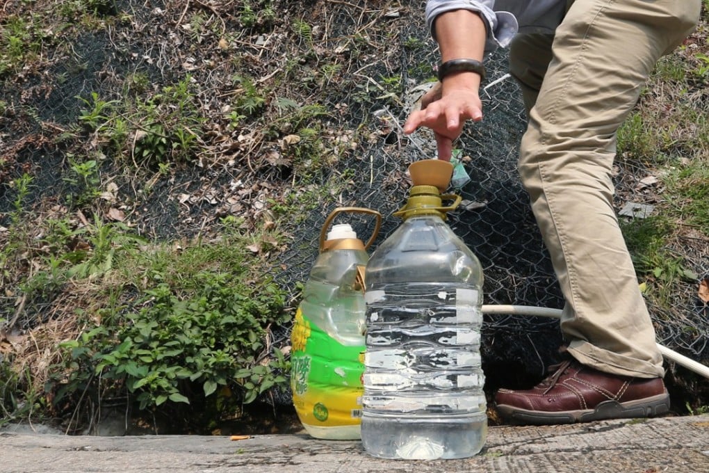 A man collects untreated spring water from a makeshift waterspout in a Hong Kong hillside on Hong Ning Road, Kwun Tong. Photo: SCMP Picture