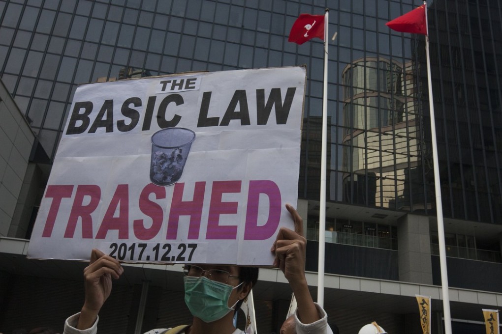 man holds a banner at Civic Square outside the Hong Kong government's headquarters during the annual New Year's Day street protest. Photo: EPA