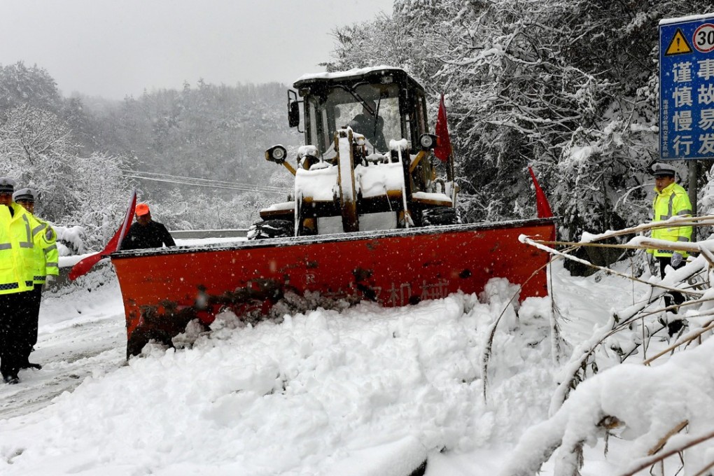 A snow grader clears a path on a dangerous road in Nanzhang county, Hubei province. Photo: Xinhua
