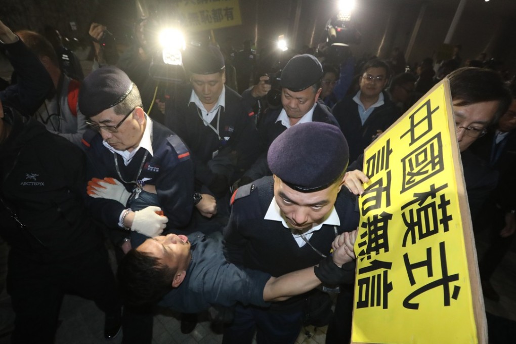 A protester who refused to leave is removed from Civic Square outside the government headquarters in Tamar. Photo: Sam Tsang