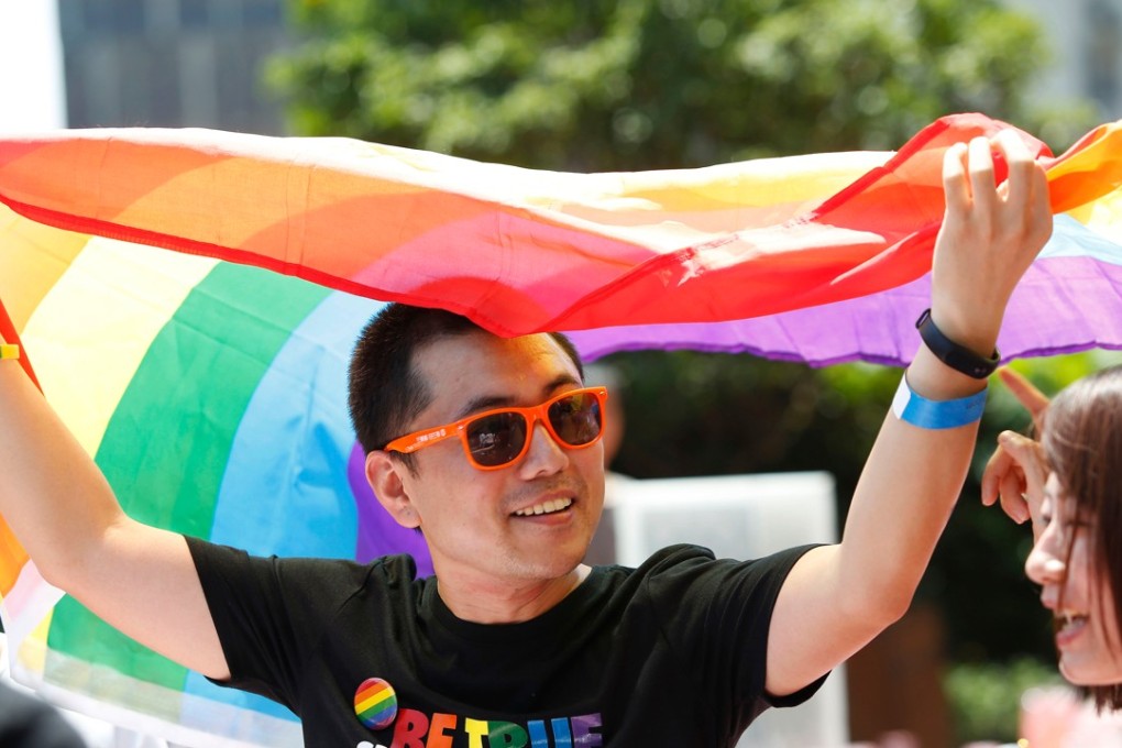 A man holds a rainbow flag after taking part in the Pride Run in Shanghai. The media regulator faces a legal challenge over rules that ban content depicting gay relationships. Photo: AFP