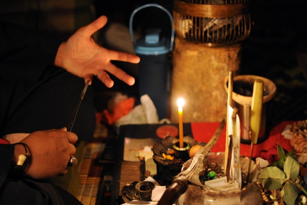 A Malay Bomoh, or witch doctor, explains his treatments in front of paraphanelia he uses to cure patients of their ailments on the outskirts of Kuala Lumpur. Photo: AFP/Saeed Khan