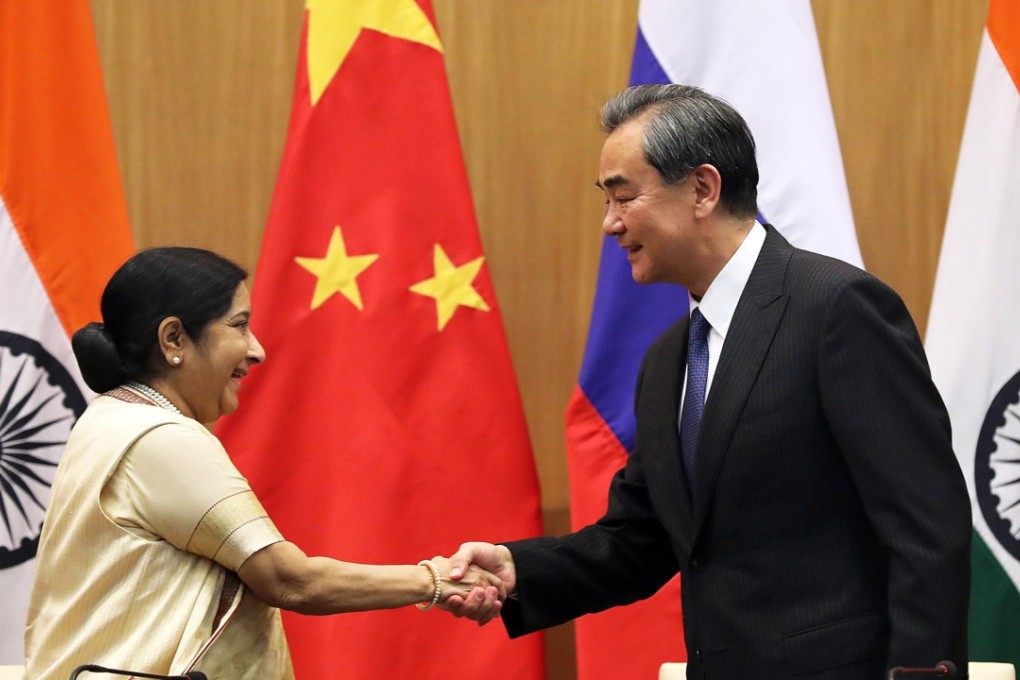 Indian Foreign Minister Sushma Swaraj (L) shakes hands with her Chinese counterpart Wang Yi (R) during a joint press statements after the Russia-India-China foreign ministerial meeting in New Delhi, on December 11, 2017. Photo: EPA-EFE