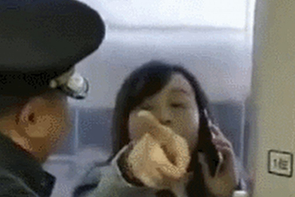 A member of staff tries to get the woman to stop blocking a train door. Photo: Thepaper.cn
