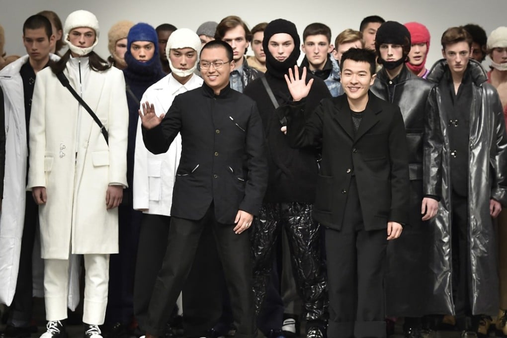 Yushan Li and Jun Zhou salute the crowd at the end of their show during London Fashion Week Men’s event.