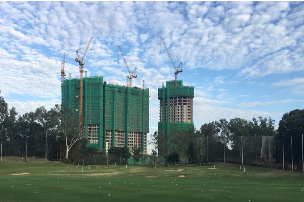A new housing development towers over the driving range at Hong Kong Golf Club in Fanling. Photo: SCMP
