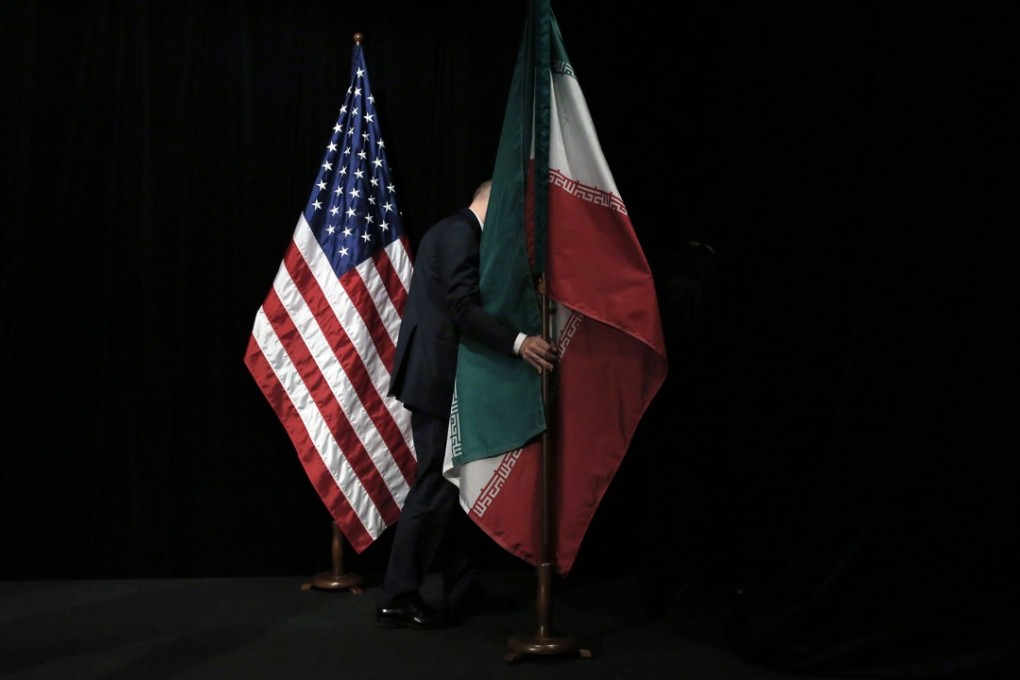 An Iranian flag is removed from the stage after a group picture during nuclear talks in Vienna in July 2015. Calls to uphold the deal have mounted ahead of Donald Trump’s announcement. Photo: AFP