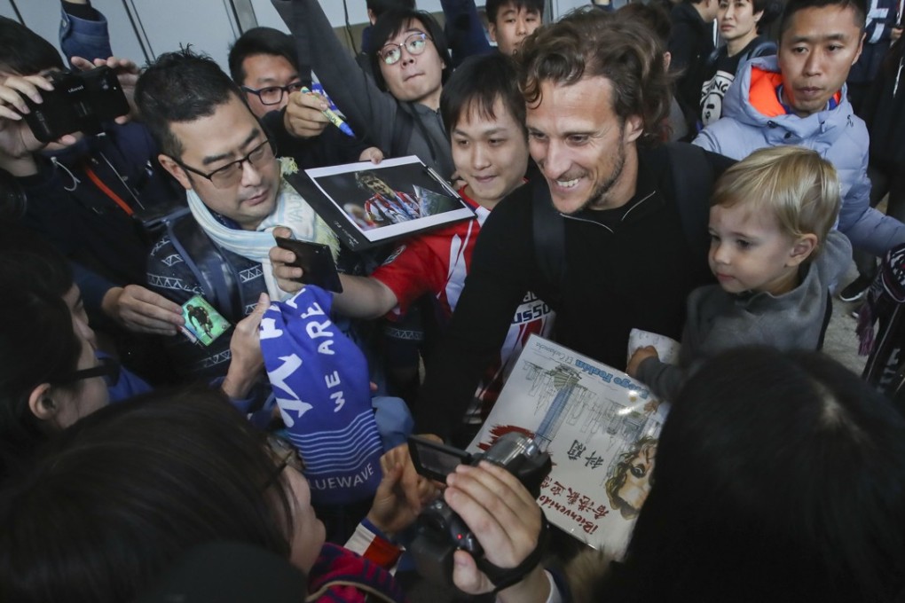 Diego Forlan greets fans after arriving at Hong Kong International Airport. Photo: Edward Wong
