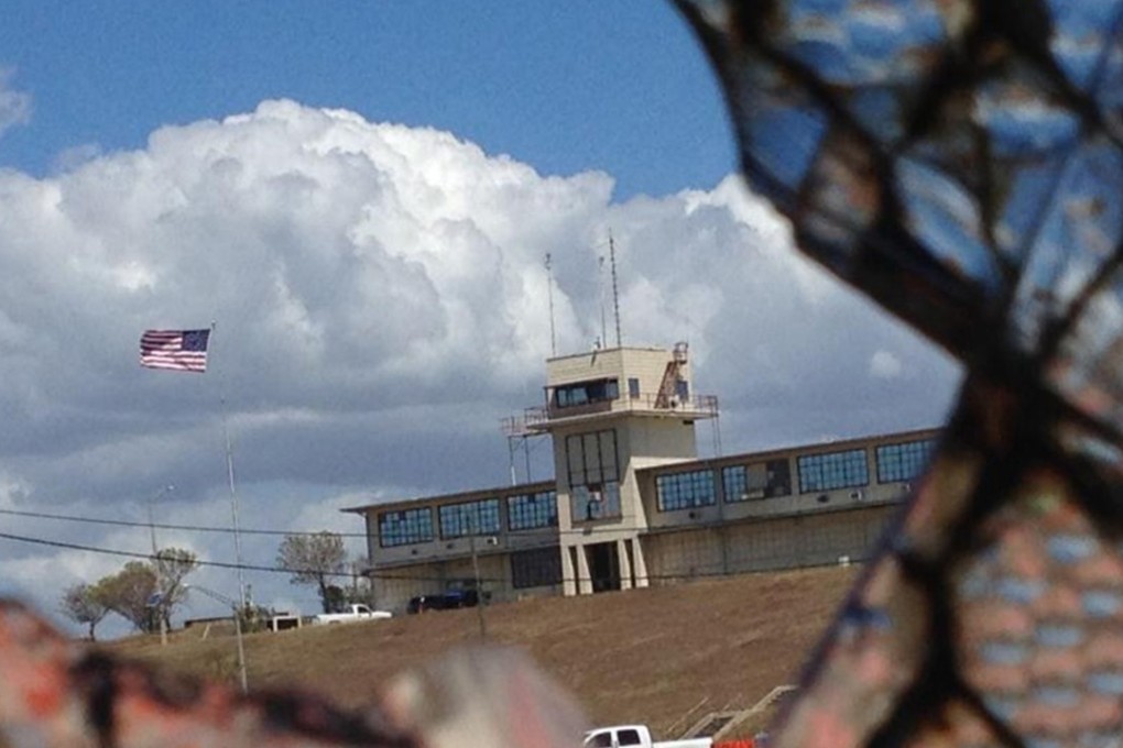 The war court headquarters at Camp Justice, as seen through a broken window at an obsolete air hangar at the US Navy base at Guantanamo Bay, Cuba, on February 28, 2015. Several detainees have sued because of years of detention without charge at the facility. Photo: Miami Herald/TNS