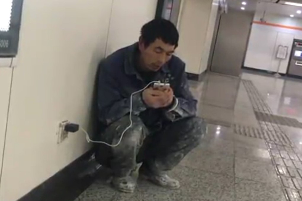 Chinese migrant worker Ge Yuanzheng crouches in a Shanghai subway station to make his daily video call home to his wife and children in central China’s Henan province. Photo: Chinanews.com
