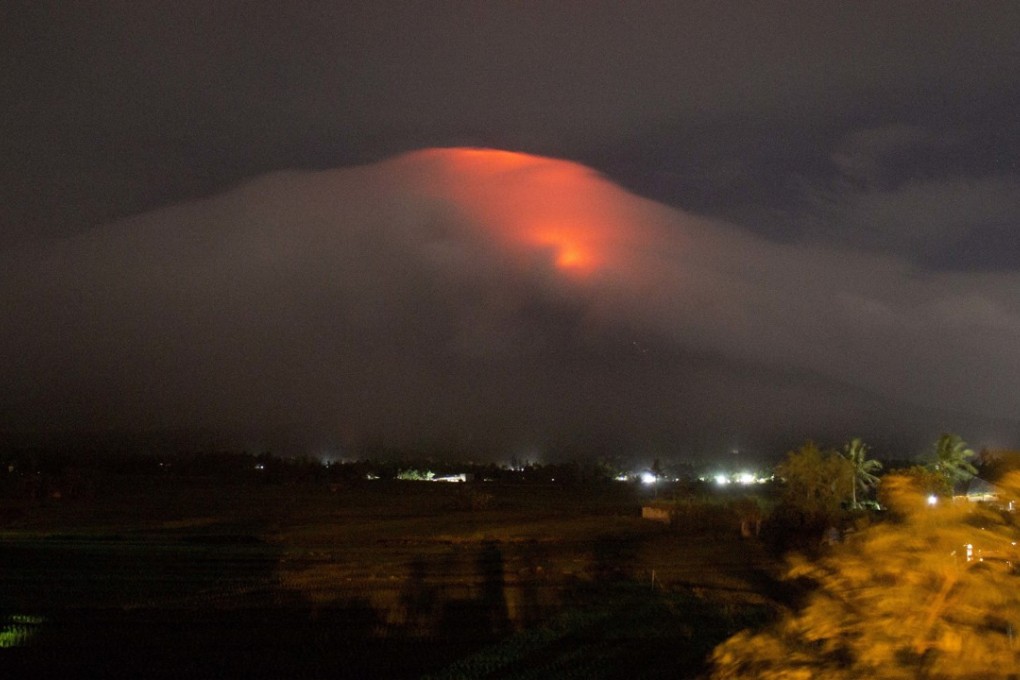 An orange glow is seen at the cloud-shrouded crater of Mayon volcano at Legazpi city. Photo: AP