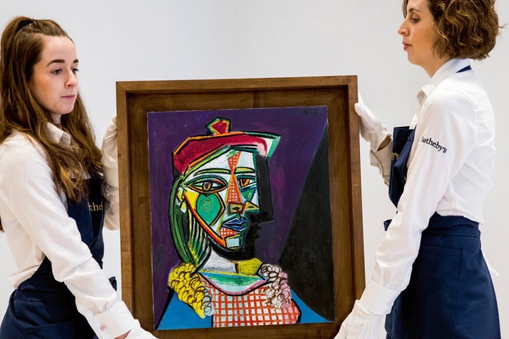 Sotheby’s staff hold Pablo Picasso’s 1937 portrait Femme au béret et à la robe quadrillée (Marie-Thérèse Walter). Photo: Courtesy of Sotheby's