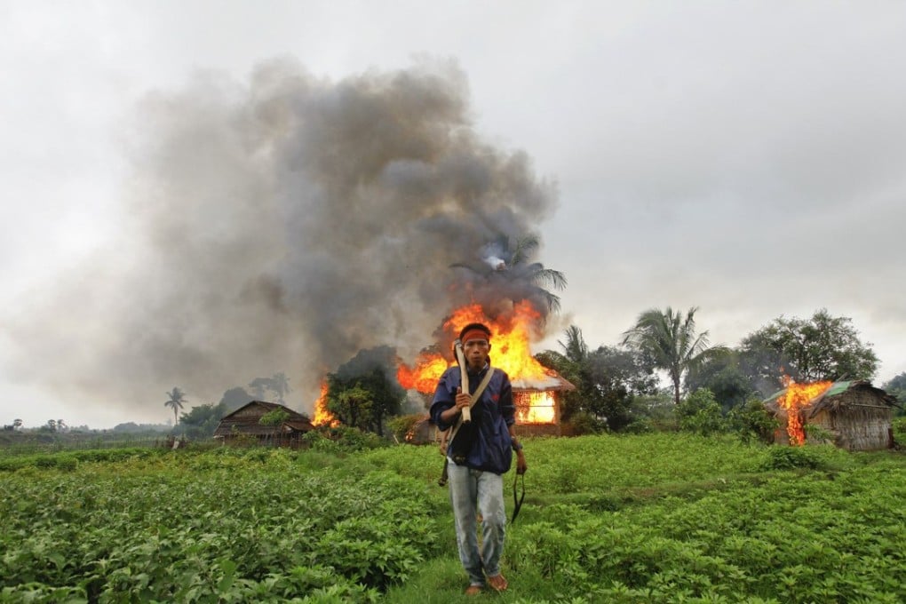 A Buddhist Rakhine man walks away from houses torched during fighting between Rakhine and Muslim Rohingya communities in the Rakhine State capital of Sittwe. Picture: Reuters