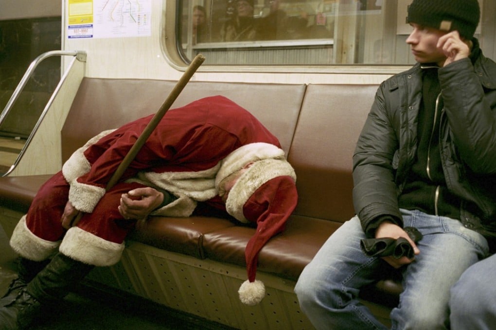 A drunk man dressed as Santa Claus sleeps on an underground train in Moscow in this January 1, 2006 file photo. Photo: AP