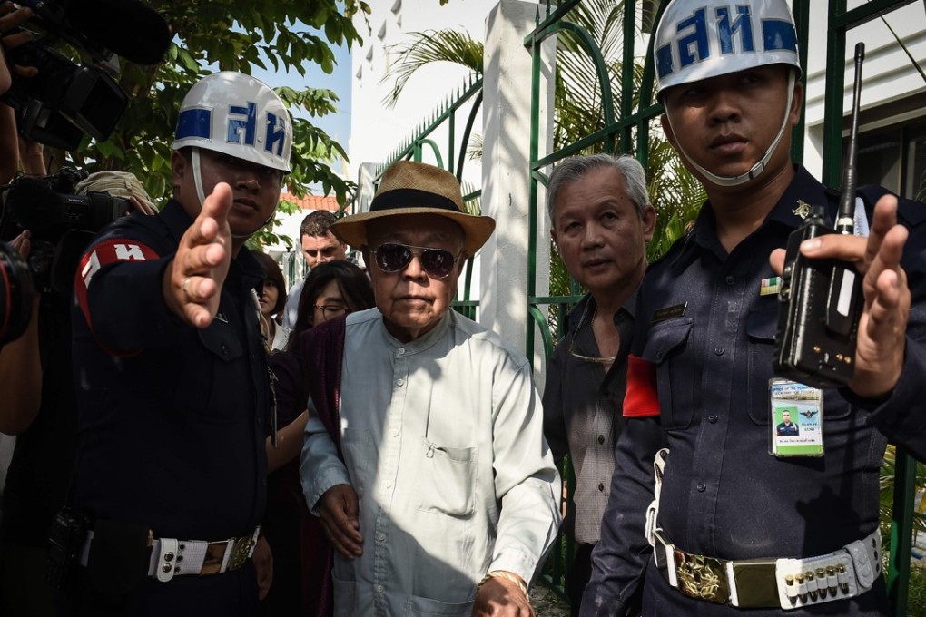 Thai academic and historian Sulak Sivaraksa is escorted by police from the Bangkok Military Court. Photo: AFP