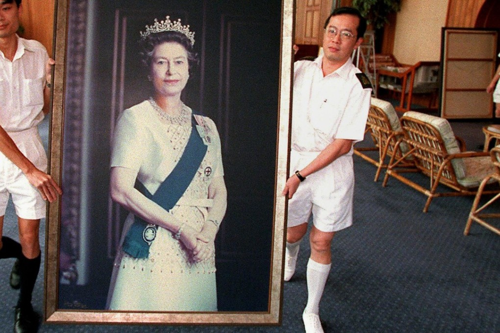 Two sailors carrying a portrait of Queen Elizabeth through the HMS Tamar ahead of the end of British rule in Hong Kong. Photo: AFP
