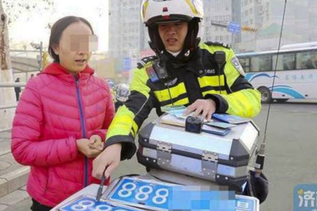 The woman shows a police officer what she claimed were her real plates. Photo: News.163.com