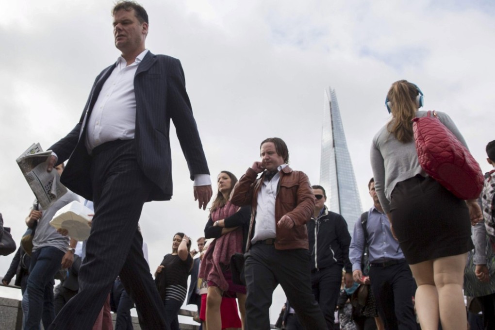 Commuters cross London Bridge in London. Photo: REUTERS/Neil Hall