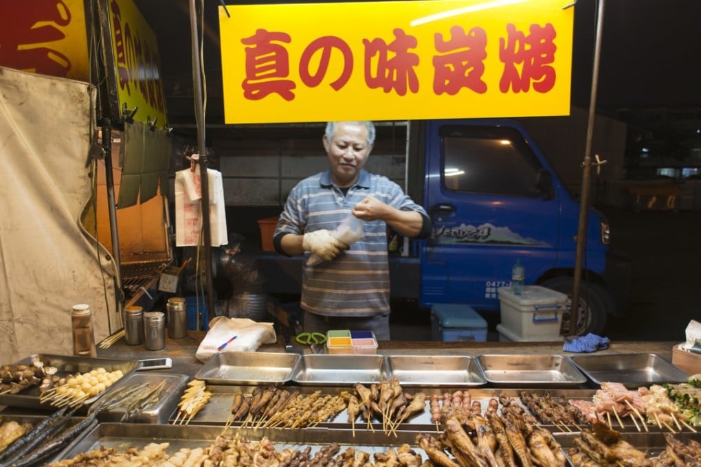 A vendor sells grilled meats on a skewer at a night market in Tainan, Taiwan. Picture: Antony Dickson