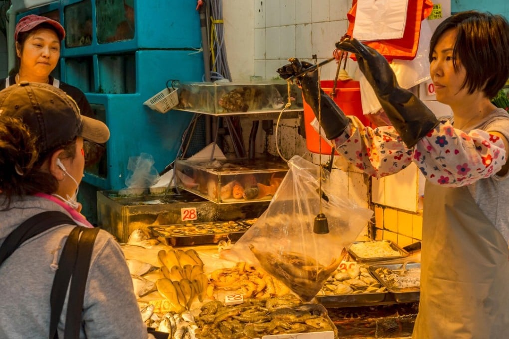 A seafood vendor weighs shrimp at a market in Hong Kong.