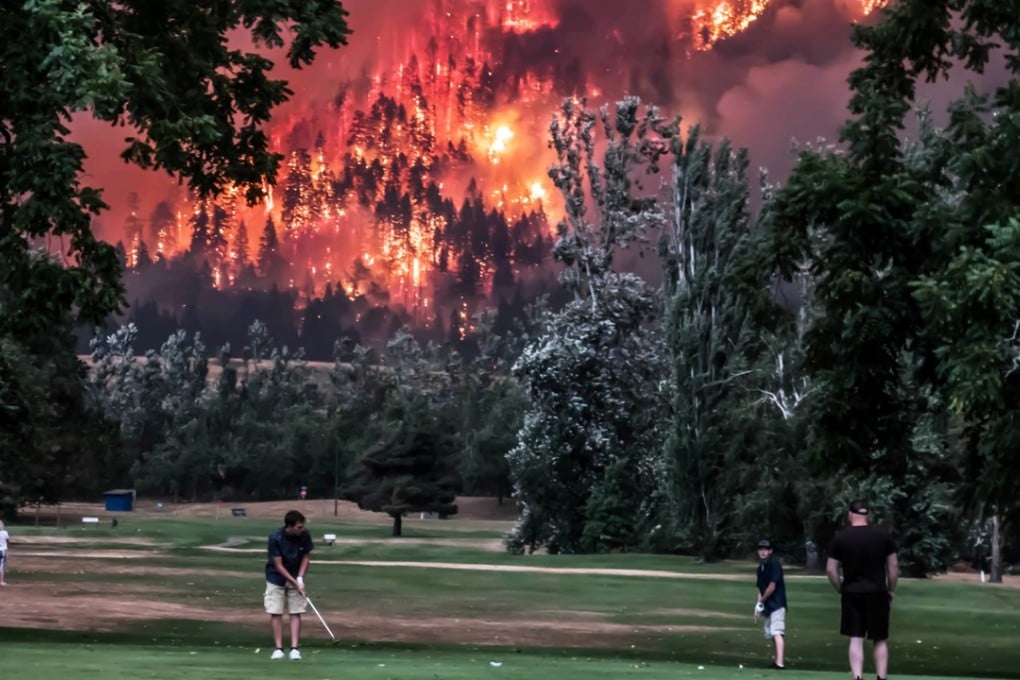 A wildfire burns as golfers play at the Beacon Rock Golf Course in North Bonneville, Washington, on September 4, 2017. Some have blamed a spate of wildfires in North America on climate change, but experts are divided. Photo: Reuters