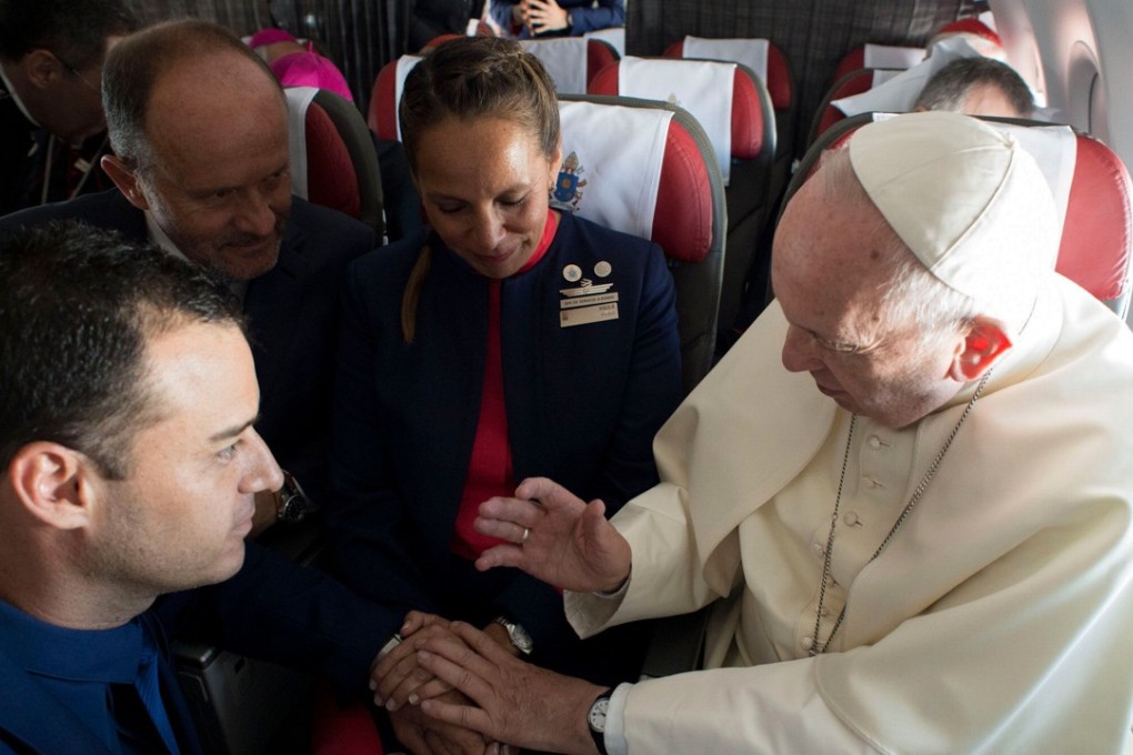 Pope Francis (right) marries LatAm airline flight attendants Paula Podest (centre) and Carlos Ciuffardi (foreground) during the flight between Santiago and the northern Chilean city of Iquique on Thursday. Their witness, Chilean businessman and one of the owners of the airline, Ignacio Cueto (second left), looks on. Photo: Agence France-Presse