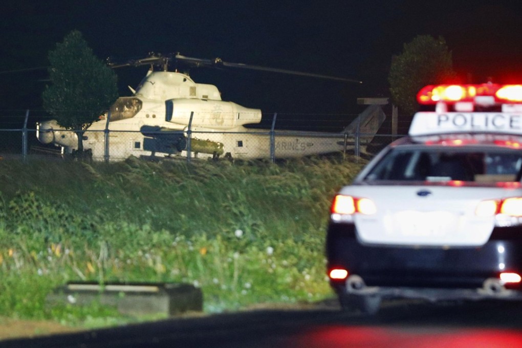 A US attack helicopter is seen outside Yomitan village on Okinawa island after an emergency landing on January 8, 2018. There have been a spate of incidents involving US helicopters on Okinawa, jangling nerves. Photo: Kyodo