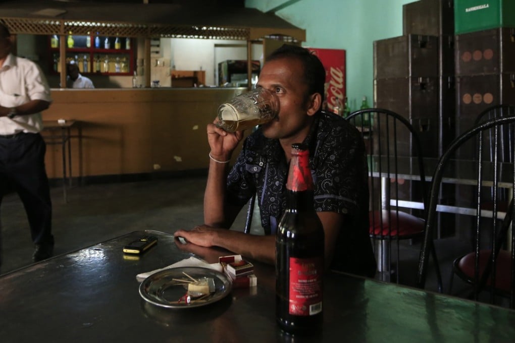 A Sri Lankan man drinks beer at a bar in Colombo. Sri Lanka revoked a 38-year ban on selling alcohol to women, only to reverse the decision a few days later. Photo: AP