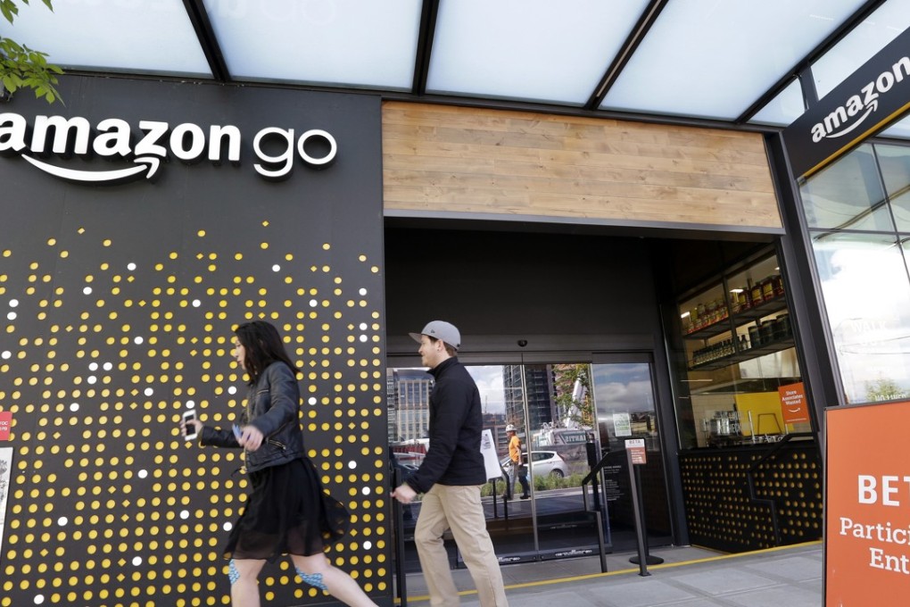 People walk past an Amazon Go store in Seattle. Amazon Go shops are convenience stores that don't use cashiers or checkout lines, but use a tracking system that of sensors, algorithms, and cameras to determine what a customer has bought. Photo: AP