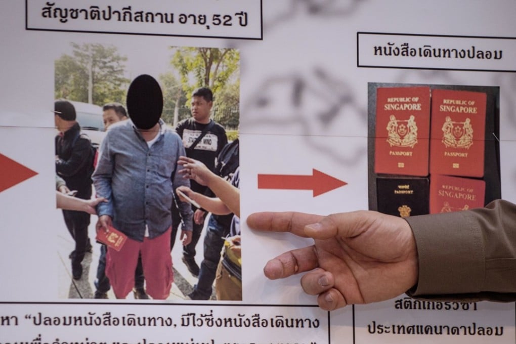Commander of the Immigration Bureau, Suttipong Vongpint, points to a board with information about an apprehended passport forger during a press conference in Bangkok. Photo: AFP
