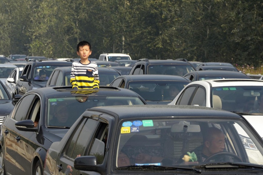 A boy looks out from the sunroof of a car stuck in a traffic jam on a Chinese motorway in this file photo. The country’s congestion problems eased in 2017, according to a recent survey. Photo: Reuters