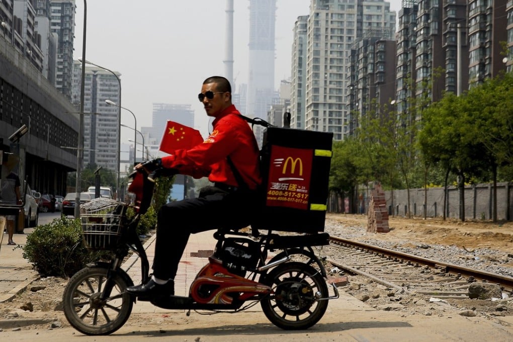 A delivery man rides past residential buildings in Beijing. Ele.me said Chinese consumers placed 8.86 million online orders for congee with minced pork and preserved egg in 2017, making it the most popular takeaway in the country. Photo: AP