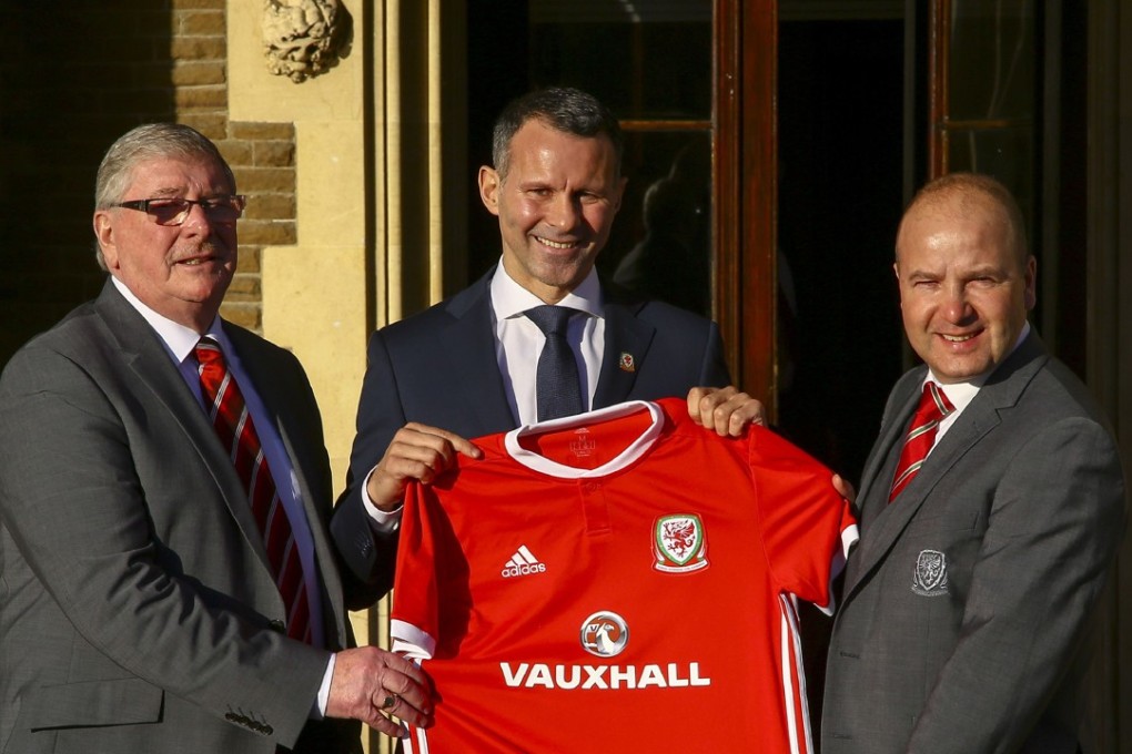 Newly appointed football manager of Wales, Ryan Giggs (C) poses for photographers at the Hensol Castle hotel, south Wales. Photo: AFP