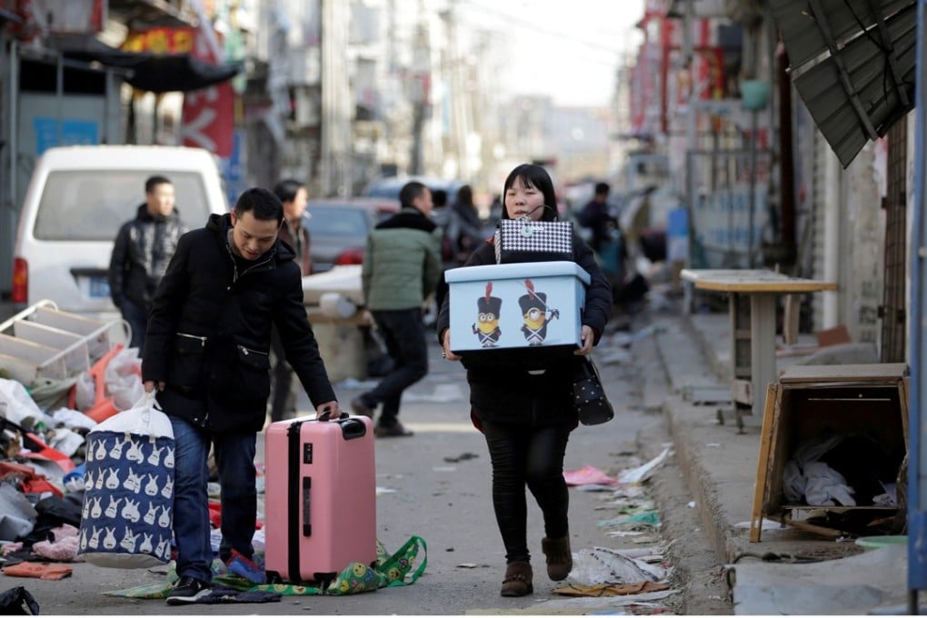A couple leave their home in November after they were required to move out in a safety campaign following a fire in the south of Beijing that claimed 19 lives. Photo: Reuters