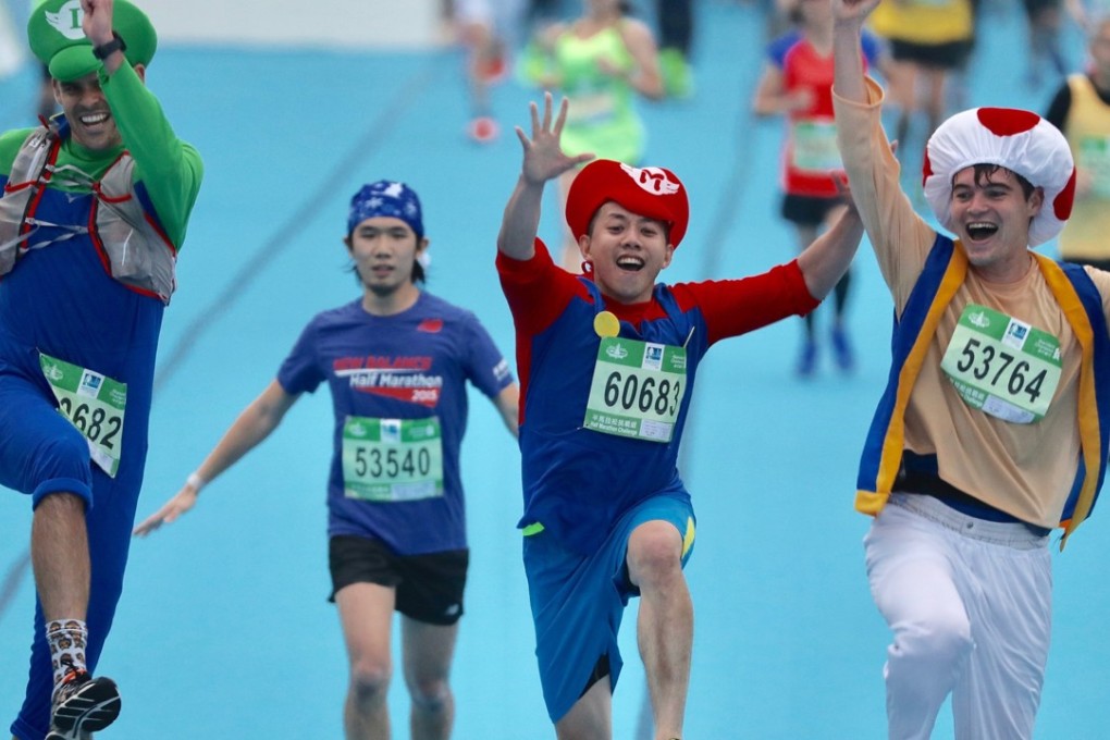 Runners dressed in Super Mario costumes cross the Hong Kong Marathon finish line at Victoria Park. Photo: Nora Tam