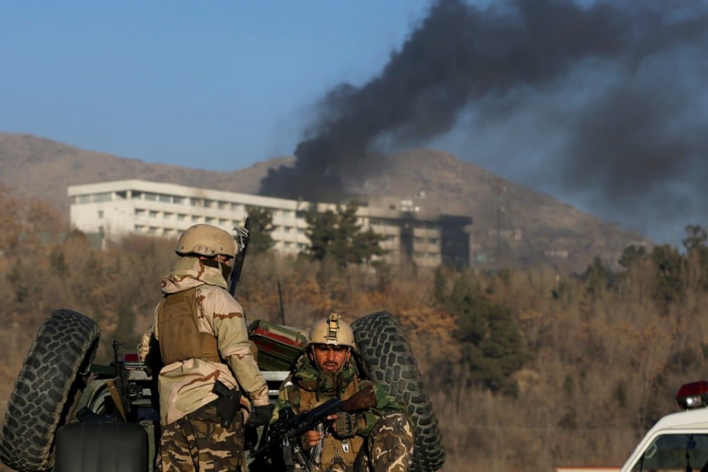 Afghan security forces keep watch as smoke pours from the Intercontinental Hotel in Kabul on Sunday during a siege by Taliban militants. Photo: Reuters